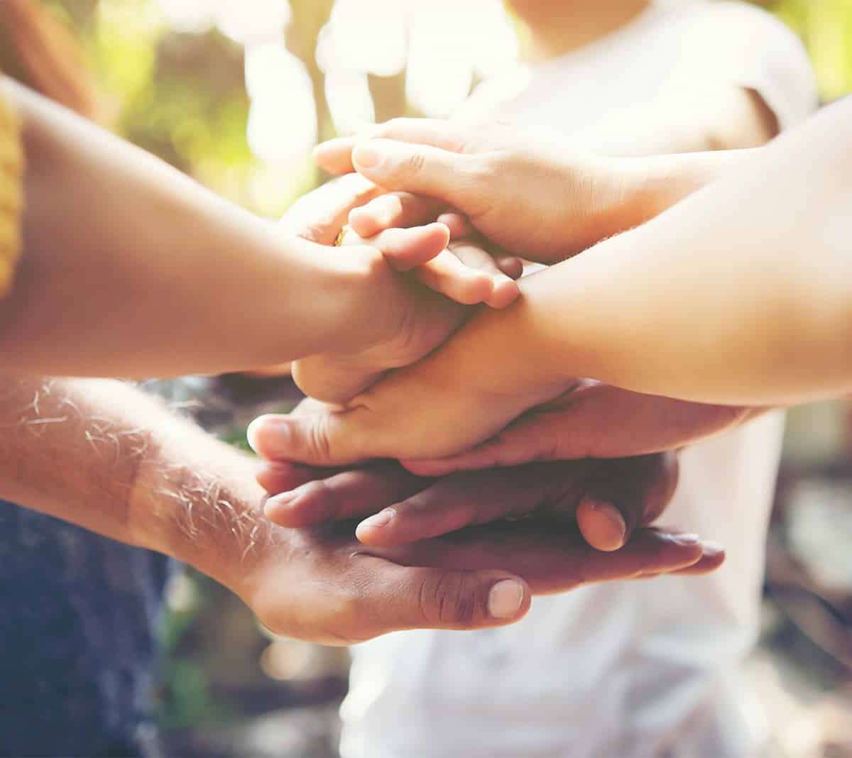 Plusieurs personnes se donnent la main